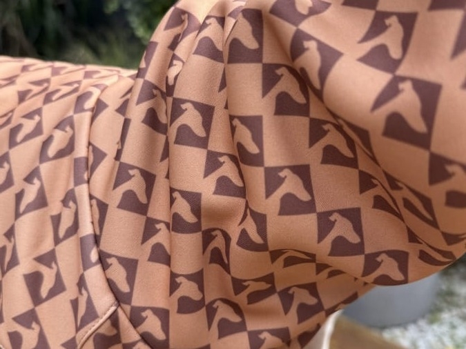 zdjęcie zblizenia na materiał,  charci wzór na brazowym bezrekawniku
